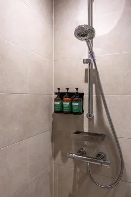 a shower with two bottles of cleaner in a bathroom at Apex City of Glasgow Hotel in Glasgow