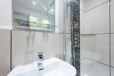 a white bathroom with a sink and a shower at Grosvenor Suites in Edinburgh