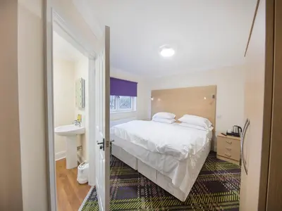 a bedroom with a white bed and a sink at The Bay Horse in Hamilton