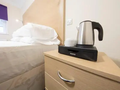 a coffee maker on top of a dresser next to a bed at The Bay Horse in Hamilton