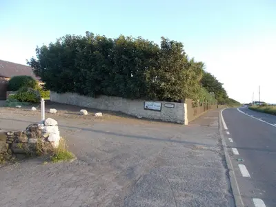 an empty road with sheep on the side of the road at Burnside Farm B & B in Girvan
