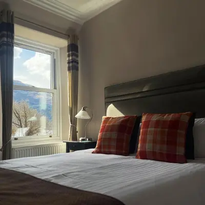 a bedroom with a bed with two pillows and a window at Creag Mhor Lodge in Onich
