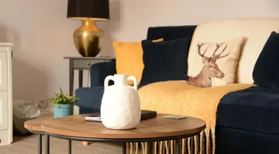 a living room with a couch and a table with a vase at Creag Mhor Lodge in Onich