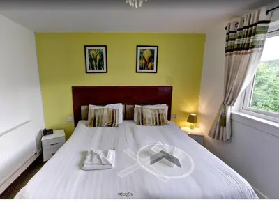 a bedroom with a bed with a peace sign on it at The County Hotel in Helensburgh