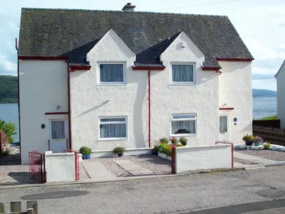 a white house with a fence in front of it at Maggie's in Inveraray