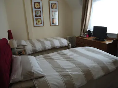 a hotel room with two beds and a desk with a television at Maggie's in Inveraray