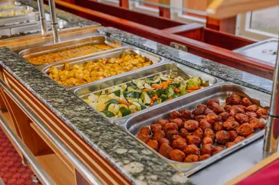 a buffet line with trays of different types of vegetables at Muthu Ben Doran Hotel in Tyndrum