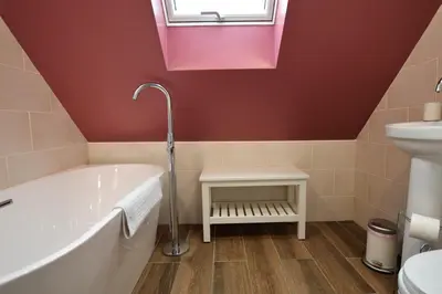 a bathroom with a tub and a sink at Alder Cottage in Blairmore