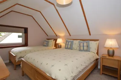 a bedroom with two beds and a window at Larch Cottage in Blairmore