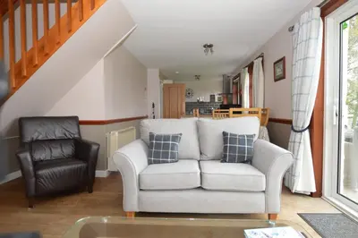 a living room with a couch and a chair at Larch Cottage in Blairmore