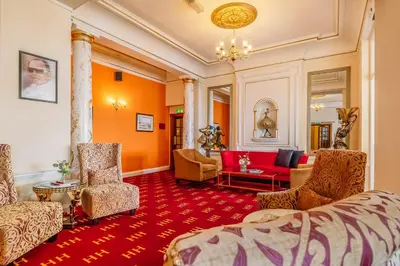 a hotel room with orange walls and a red carpet at Muthu Alexandra Hotel in Oban