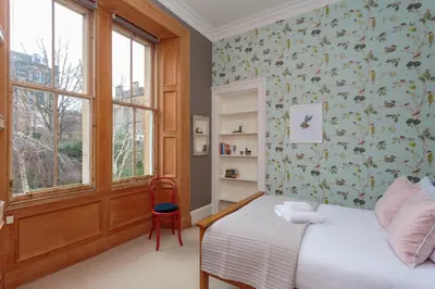 a bedroom with a bed and a window at South Learmonth Gardens Apartment in Edinburgh