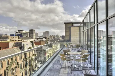 a balcony with tables and chairs on a building at Kimpton Blythswood Square Hotel & Spa by IHG in Glasgow