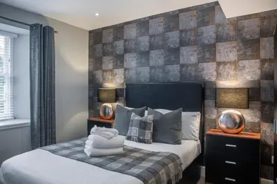 a bedroom with a bed with two lamps on it at The Allan Park in Stirling