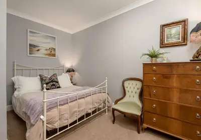 a bedroom with a bed and a dresser and a chair at The Lauderdale Street Residence in Edinburgh