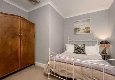 a bedroom with a bed and a wooden cabinet at The Lauderdale Street Residence in Edinburgh