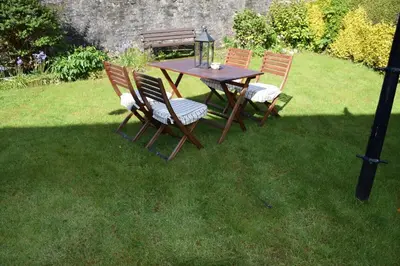 a wooden table and chairs in the grass at One Marine Place in Port Bannatyne