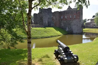 a cannon sitting on the grass in front of a castle at One Marine Place in Port Bannatyne