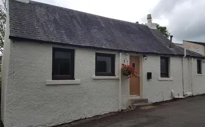 a white house with windows and a door at Cobbler's Cottage in Dunblane