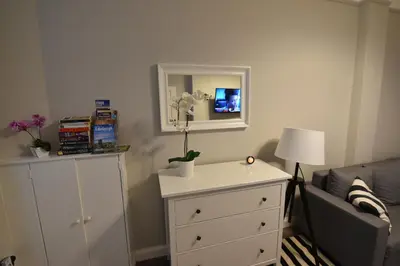 a bedroom with a dresser and a bed with a mirror at Slateford House Apartment Ground Floor Main Door in Edinburgh