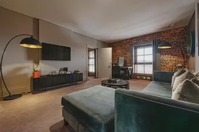 a living room with a couch and a tv at Dakota Edinburgh in Queensferry