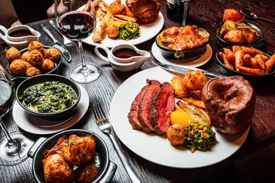 a table topped with plates of food and glasses of wine at Dakota Edinburgh in Queensferry