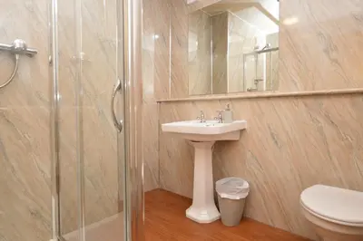 a bathroom with a toilet and a sink and a shower at Taigh na Mara in Kames