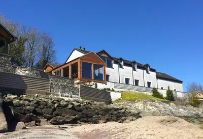a house on top of a hill with rocks at Taigh na Mara in Kames