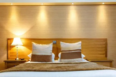 a bedroom with a large bed with two pillows at Adamson Hotel in Dunfermline