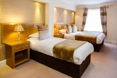 a hotel room with two beds and a window at Adamson Hotel in Dunfermline