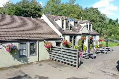 a house with flowers on the side of it at Auld Mill House Hotel in Dunfermline