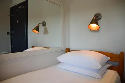 a bedroom with a mirror and a bed with white pillows at Dalrigh House in Oban