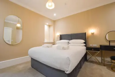 a bedroom with a large bed with a large mirror at Dalrigh House in Oban