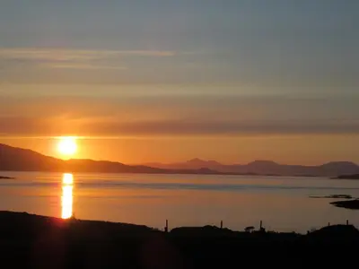 a sunset over a body of water at Aird Farm Holiday Cottages in Ardfern