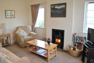 a living room with a couch and a fireplace at Aird Farm Holiday Cottages in Ardfern