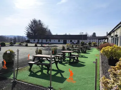 a group of picnic tables in a parking lot at Rob Roy Hotel in Aberfoyle