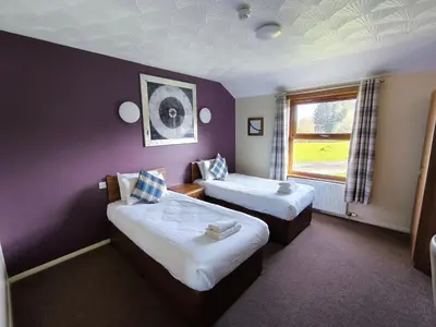 a hotel room with two beds and a window at Rob Roy Hotel in Aberfoyle
