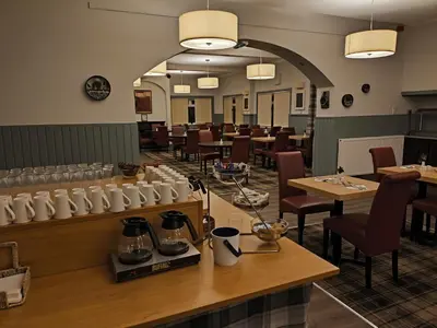 a dining room with tables and chairs in a restaurant at Rob Roy Hotel in Aberfoyle
