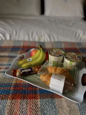 a tray of food on a bed with bananas and other foods at Ivybank Villa in Rothesay