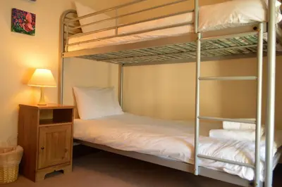 a bedroom with two bunk beds and a lamp at Culzean House in Ardentinny