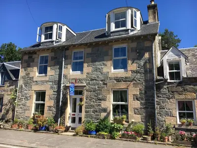 an old stone house on the corner of a street at Rosebank House Bed & Breakfast in Strathyre