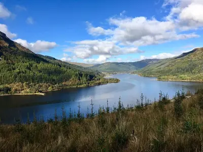 a river in the middle of a valley with mountains at Rosebank House Bed & Breakfast in Strathyre