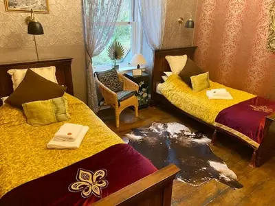 a bedroom with two beds with a mess on the floor at Rosebank House Bed & Breakfast in Strathyre