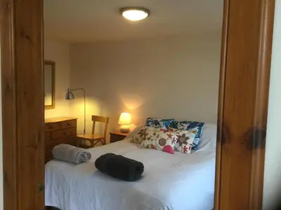 a bedroom with a bed with two bags on it at Oban Seil Farm The Bothy in Clachan