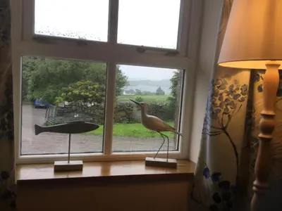 a window with a bird statue on a window sill at Oban Seil Farm The Bothy in Clachan