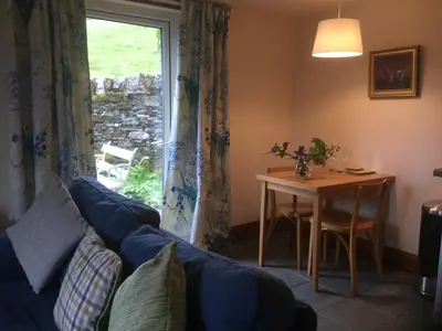 a living room with a couch and a table and a window at Oban Seil Farm The Bothy in Clachan
