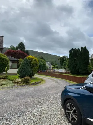 a blue car parked on the side of a road at Garbhein Bed & Breakfast in Kilmelford