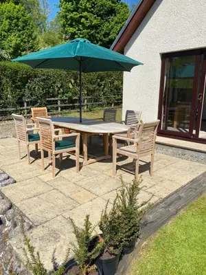 a table and chairs with an umbrella on a patio at Garbhein Bed & Breakfast in Kilmelford