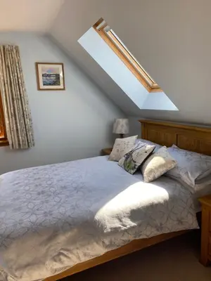 a bedroom with a large bed with a roof at Garbhein Bed & Breakfast in Kilmelford
