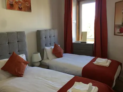 a hotel room with two beds and a window at Scotstoun Appartments in Glasgow